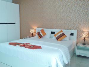 a bedroom with a large white bed with two lamps at Grand Residence Jomtien in Jomtien Beach