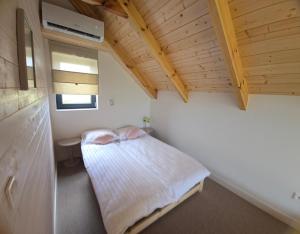 a small bedroom with a bed in the attic at Port Stobno - Portowe Domki przy Winnicy  +35 photos