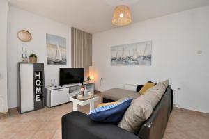 a living room with a couch and a tv at House Velebit by the sea in Stinica