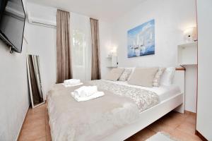 a bedroom with a white bed with towels on it at House Velebit by the sea in Stinica