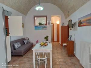 a living room with a table and a couch at Casa Carmela 53 in Ragusa