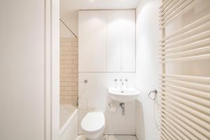 een witte badkamer met een toilet en een wastafel bij Stunning 3 Bedroom Flat in Mayfair in Londen