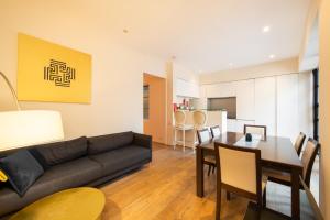 een woonkamer met een zwarte bank en een tafel bij Stunning 3 Bedroom Flat in Mayfair in Londen