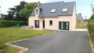 a house with a driveway in front of it at Maison de vacances - 6 à 8 personnes in Cléder