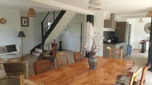 a living room with a wooden table and a kitchen at Maison de vacances - 6 à 8 personnes in Cléder +46 photos
