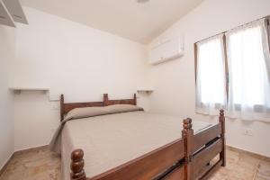 a bedroom with a bed in a room with a window at Villa Nella in Cala Liberotto