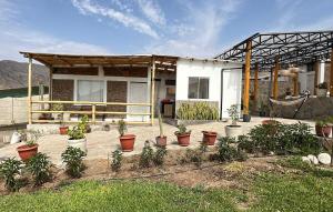 une maison avec des plantes en pot devant dans l'établissement Casa campo vista linda, à Mala