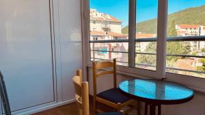 a table and a chair in a room with a window at Budva Summer House in Budva