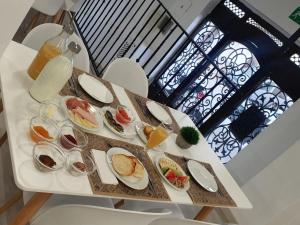 a table with several plates of food on it at Canaan Boutique Hotel Ronda in Ronda