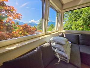 a room with a couch and two large windows at Innsbruck Nature & City House I Free Parking in Innsbruck +11 photos