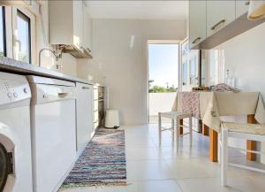 a kitchen with white appliances and a table and chairs at Casa da Avó Ti in Azoia