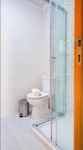 a bathroom with a toilet and a glass shower at Casa da Avó Ti in Azoia +18 photos