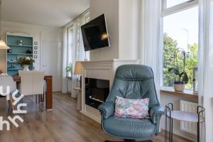 a living room with a chair and a fireplace at OV517 - 6 persons holiday home De Kersenboomhoeve in Zuidveen