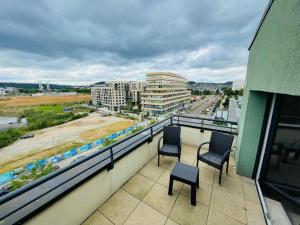 2 Stühle auf einem Balkon mit Stadtblick in der Unterkunft Terrasse & Confort à Rouen - 396 in Rouen