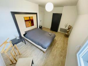 ein Schlafzimmer mit einem Bett und einem Gemälde an der Wand in der Unterkunft Terrasse & Confort à Rouen - 396 in Rouen