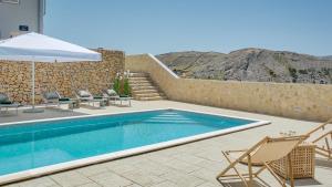 ein Swimmingpool mit Stühlen und einem Sonnenschirm in der Unterkunft Vila Romana by Resort Čulina in Metajna