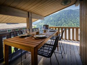シャテルにあるChalet Amarou - OVO Networkの木製テーブルと椅子付きのデッキから眺めの良い景色を望めます。