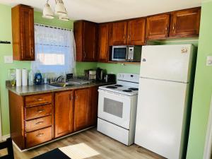 a kitchen with wooden cabinets and a white refrigerator at Fancy Nancy Place II in Kentville