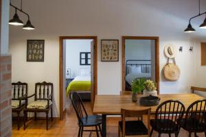 a dining room with a table and chairs and a bed at Casas Porta Alegre in Portalegre