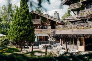a large building with a patio and a tree at Les Chalets du Mont d'Arbois & Spa, Megève in Megève