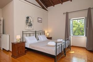 a bedroom with a bed and a window at Villa Moyria by PosarelliVillas in Kassiopi +19 photos