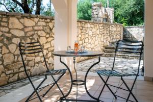 a table and two chairs on a patio at Villa Moyria by PosarelliVillas in Kassiopi