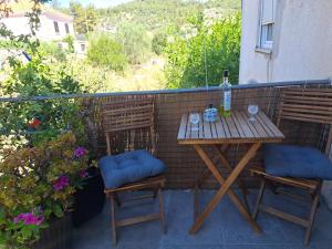 a table with two chairs and a bottle of wine on a balcony at Smještaj Latica in Vela Luka