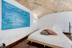 un letto in una stanza con un dipinto sul muro di Casa Valentina - Oasi di tranquillità e stile a Testaccio a Roma