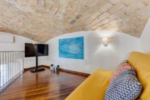 un soggiorno con divano e TV a schermo piatto di Casa Valentina - Oasi di tranquillità e stile a Testaccio a Roma