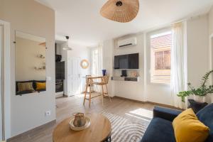 a living room with a blue couch and a table at Bandol - Appartement Corneille in Bandol