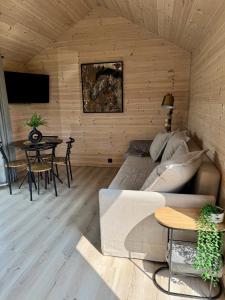 a living room with a couch and a table at Mēness Namiņš in Vidriži