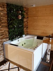 a jacuzzi tub in a room with a hedge at L'Idylle Moment de Détente in Nay