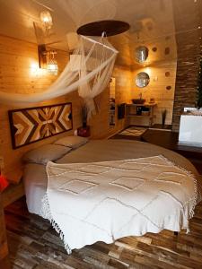 a bedroom with a bed with a mosquito net at L'Idylle Moment de Détente in Nay
