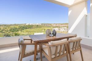 a dining room with a wooden table and chairs at Apartamentos Deluxe Azahar Estepona Sea Views 1-2 in Estepona