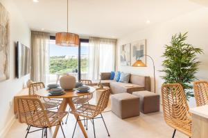 a living room with a table and chairs and a couch at Apartamentos Deluxe Azahar Estepona Sea Views 1-2 in Estepona