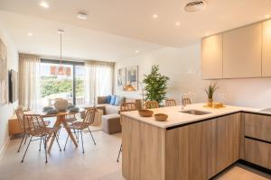 a kitchen and living room with a table and chairs at Apartamentos Deluxe Azahar Estepona Sea Views 1-2 in Estepona