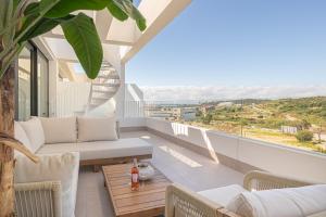 a living room with a couch and a table on a balcony at Apartamentos Deluxe Azahar Estepona Sea Views 1-2 in Estepona
