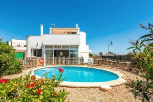 a swimming pool in front of a house at Villa Bini Mestral by Villa Plus in Binibeca
