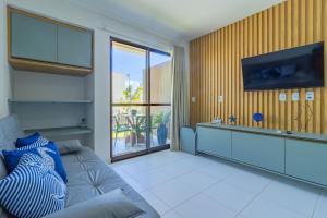 a living room with a couch and a tv at Malia Beach #D14 - Apartamento por Carpediem in Cupe