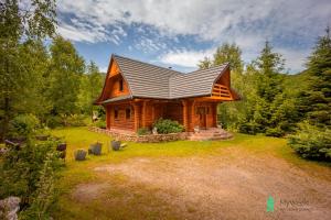a log cabin with a metal roof on a yard at Dom w Górach Stołowych MyWeek in Wambierzyce