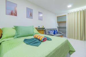 a bedroom with a green bed with towels on it at Malia Beach #D14 - Apartamento por Carpediem in Cupe +36 photos