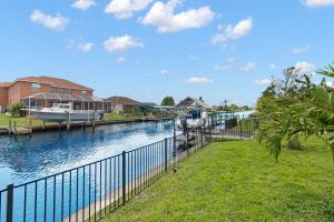 a river with a boat docked next to a house at Little Slice in Cape Coral