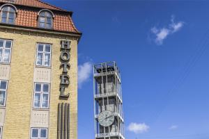 a tall building with a clock on the side of it at Scandic The Mayor in Aarhus