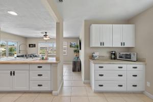 a kitchen with white cabinets and a microwave at Little Slice in Cape Coral