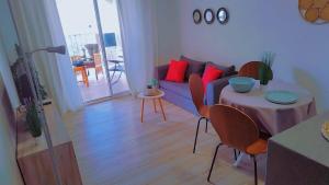 un salon avec un canapé et une table avec des chaises dans l'établissement Apartamento reformado con terraza vistas al mar y a las piscinas de Magic World garaje y piscina frente a Balneario Aire acondicionadowifi, à Oropesa del Mar