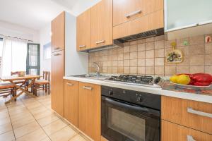 a kitchen with a stove and a bowl of fruit at AffittaSardegna - Domo Pineta in Santa Lucia