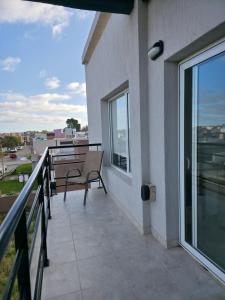 einen Balkon mit einer Bank und Straßenblick in der Unterkunft Moderno y equipado Departamento - Viedma in Viedma + 1 Foto