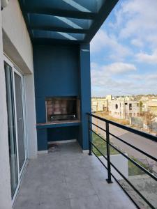 ein Balkon mit blauer Wand und Kamin in der Unterkunft Moderno y equipado Departamento - Viedma in Viedma