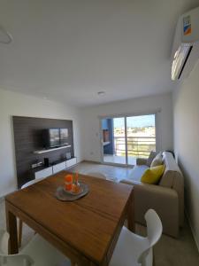 ein Wohnzimmer mit Tisch und Couch in der Unterkunft Moderno y equipado Departamento - Viedma in Viedma