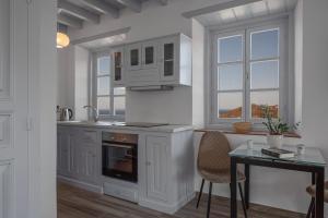 a kitchen with white cabinets and a table and window at Apartment Nektarios in Grikos